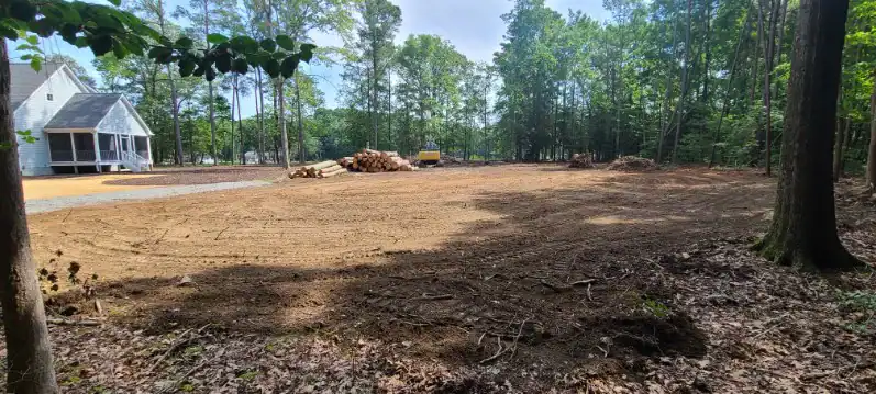 A dirt field with trees in the background, perfect for land clearing Virginia projects or future residential excavation Virginia developments.